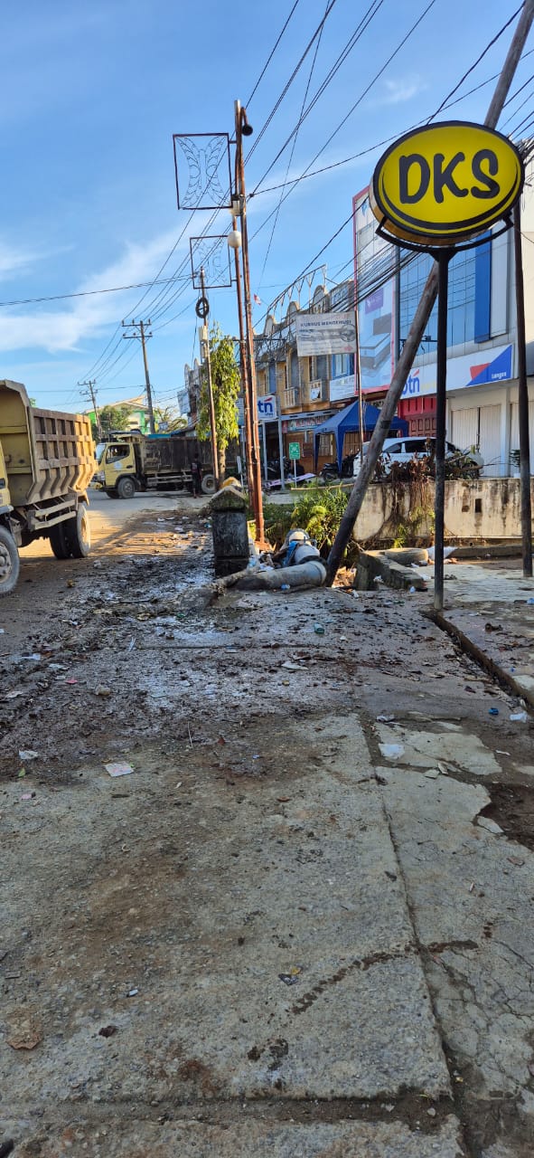 Petugas kebersihan DLH Kota Langsa bersama personil Kodim 0104/Atim membersihkan timbunan sampah dan lumpur di Jalan A. Yani depan KL Café usai banjir bandang.