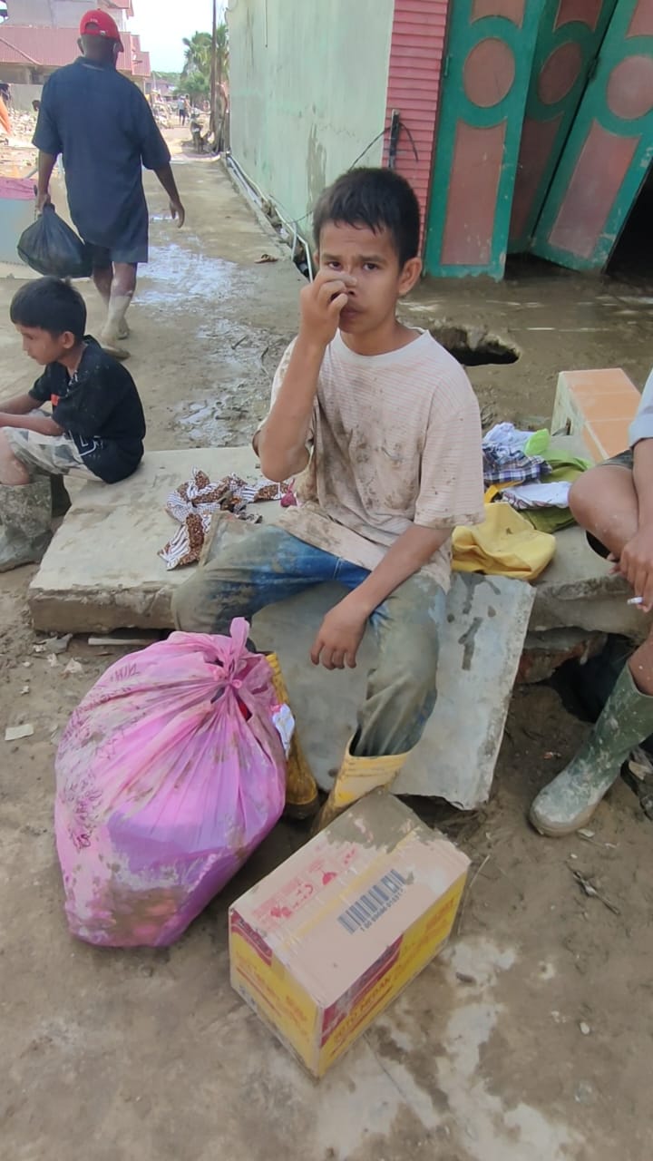 Anak-anak Aceh Tamiang berebut bantuan makanan yang dijatuhkan dari helikopter TNI di tengah lumpur pascabanjir.