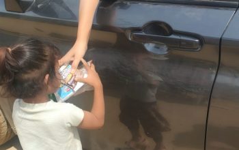 Seorang anak berdiri di tepi Jalan Lintas Medan–Banda Aceh di Karang Baru Aceh Tamiang menadahkan tangan meminta roti kepada pengguna jalan 26 hari pasca banjir bandang