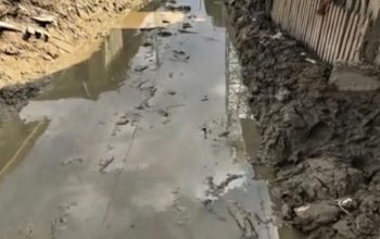 Ilustrasi jalan utama Aceh Tamiang dipenuhi debu tebal sisa lumpur banjir, warga melintas dengan jarak pandang terbatas dan gang sempit masih tertutup endapan lumpur.