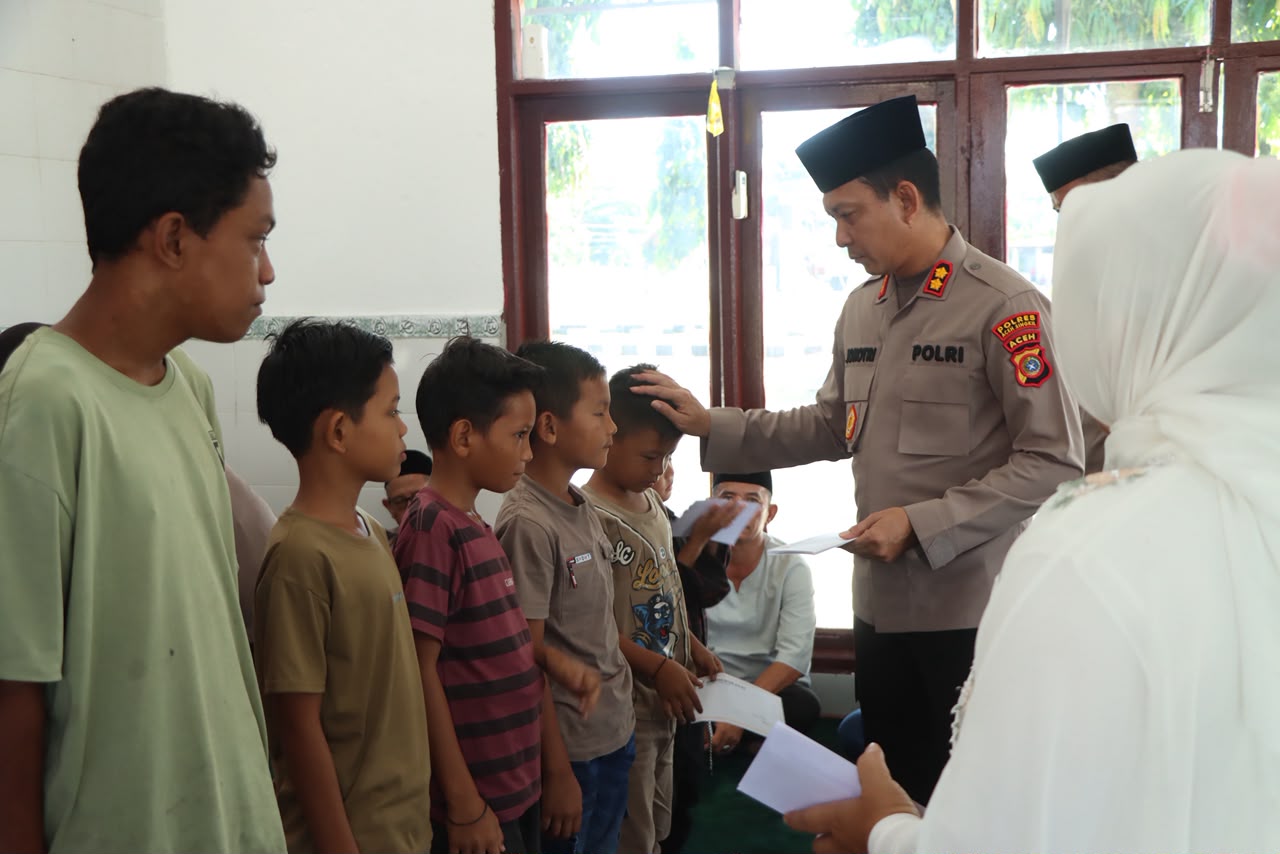 Kapolres Aceh Singkil AKBP Joko Triyono didampingi Ketua Bhayangkari Cabang Aceh Singkil menyerahkan santunan kepada anak yatim dan piatu usai zikir dan doa bersama dalam rangka Hari Bhayangkara ke-80 di Mushola At-Taqwa Polres Aceh Singkil.