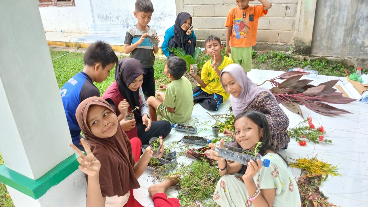 Mahasiswa KPM Mandiri Kelompok 09 UIN Sultanah Nahrasiyah Lhokseumawe bersama anak-anak menanam bunga di Perpustakaan Cerdas Bangsa Gampong Ude Aceh Utara,